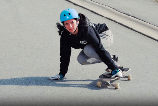 Девушка едет на лонгборде в Triple8 Sweatsaver Helmet Blue Fade