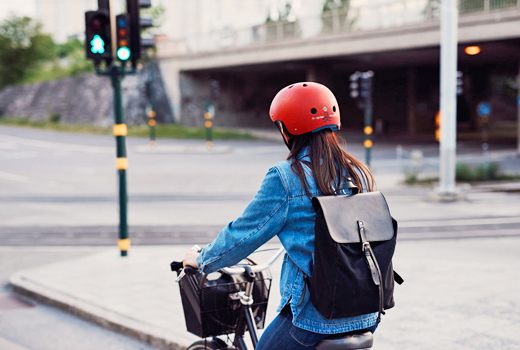 Девушка едет на велосипеде в  Triple8 Sweatsaver Helmet United Red